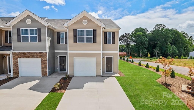 multi unit property featuring a garage and a front lawn