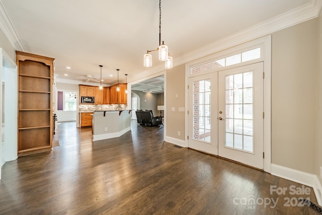 interior space with french doors, dark wood-type flooring, and ornamental molding