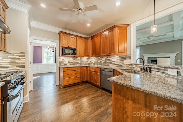 kitchen with light stone countertops, sink, dark hardwood / wood-style floors, pendant lighting, and appliances with stainless steel finishes