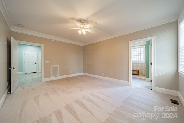 spare room featuring light carpet, ceiling fan, and ornamental molding