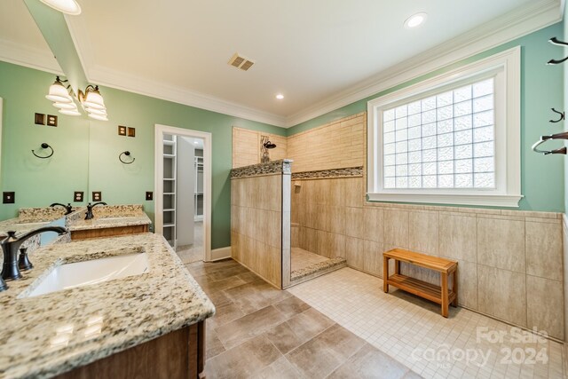 bathroom featuring vanity, ornamental molding, tiled shower, and a chandelier