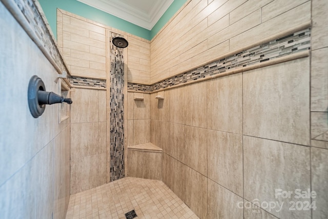 bathroom with crown molding and tiled shower