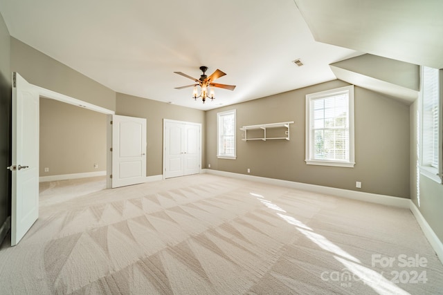 additional living space featuring ceiling fan, light colored carpet, and lofted ceiling