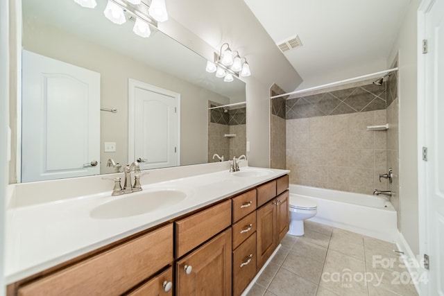 full bathroom with tiled shower / bath, tile patterned flooring, vanity, and toilet