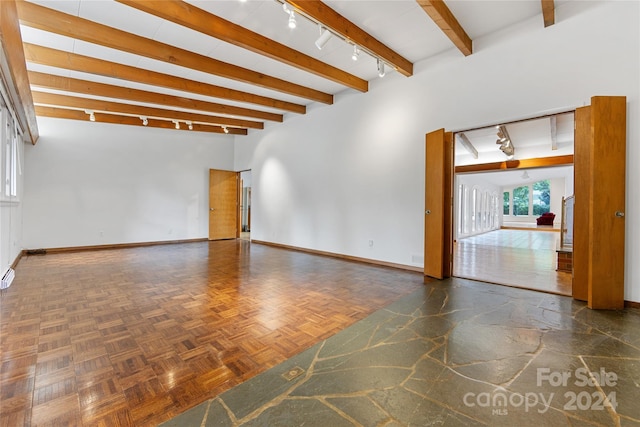 unfurnished room featuring beam ceiling, rail lighting, and dark parquet flooring