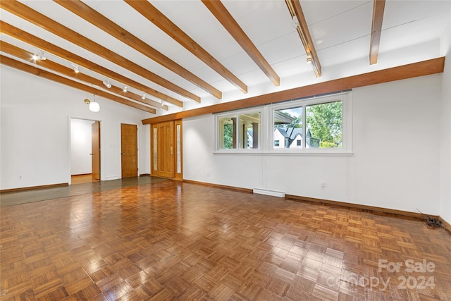 spare room with beamed ceiling and dark parquet flooring