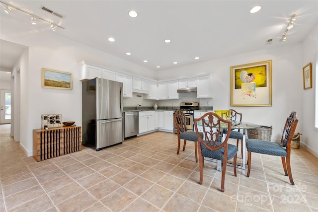 kitchen featuring white cabinetry, stainless steel appliances, and light tile patterned floors