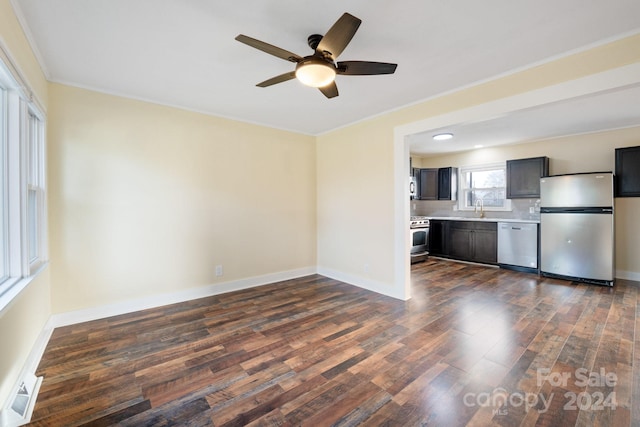 interior space with ceiling fan, sink, dark wood-type flooring, crown molding, and appliances with stainless steel finishes