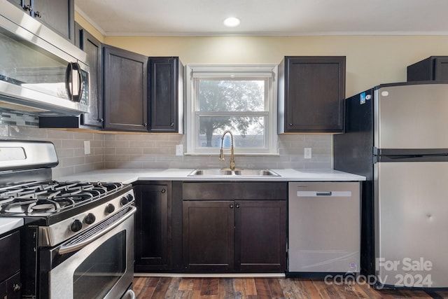 kitchen featuring dark brown cabinetry, sink, dark hardwood / wood-style floors, backsplash, and appliances with stainless steel finishes