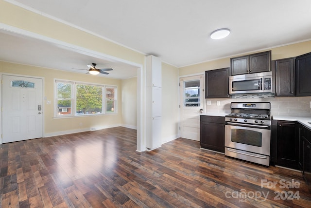 kitchen featuring ceiling fan, dark wood-type flooring, stainless steel appliances, tasteful backsplash, and crown molding