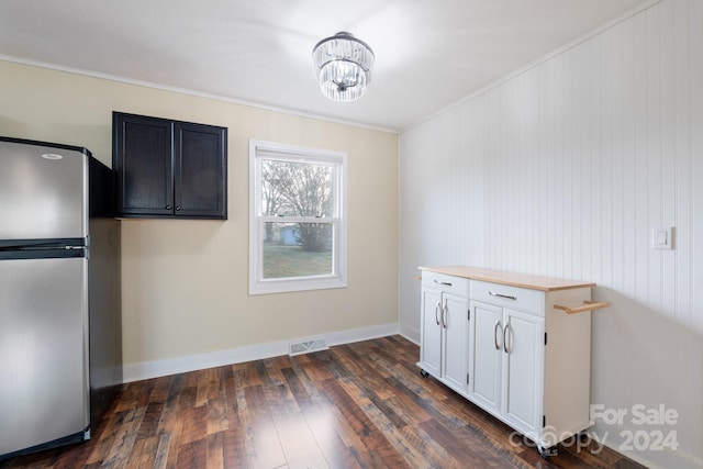 interior space with dark wood-type flooring, white cabinets, crown molding, butcher block countertops, and stainless steel refrigerator