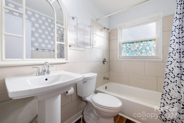 full bathroom with shower / bath combo, toilet, tile walls, and ornamental molding