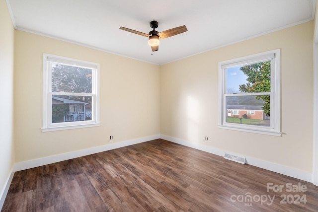 spare room featuring dark hardwood / wood-style floors, ceiling fan, and crown molding