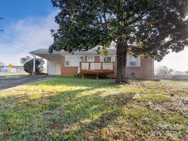 back of house with a wooden deck, a yard, and a carport