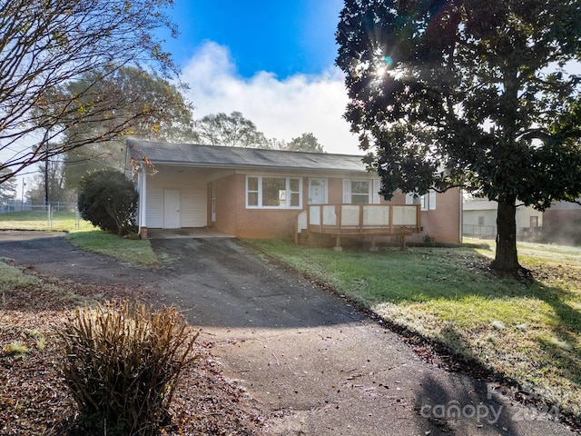 view of front facade featuring a front yard and a carport