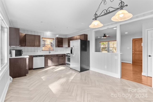 kitchen featuring dark brown cabinetry, ceiling fan, sink, hanging light fixtures, and stainless steel appliances