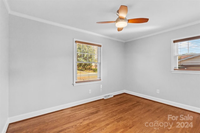 unfurnished room with crown molding, plenty of natural light, and hardwood / wood-style floors