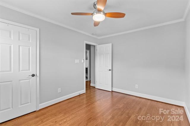 unfurnished bedroom featuring hardwood / wood-style flooring, ceiling fan, and crown molding