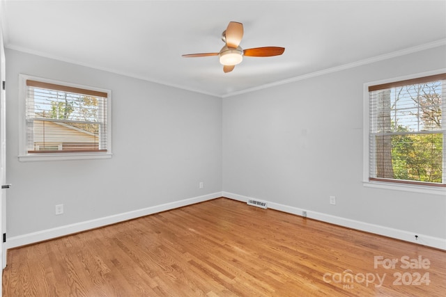 spare room featuring plenty of natural light, light hardwood / wood-style floors, and ornamental molding