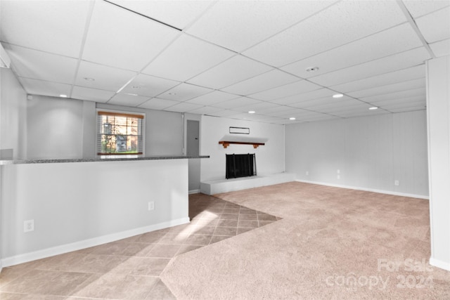 basement featuring light carpet and a drop ceiling