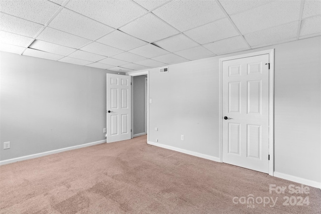 carpeted spare room with a drop ceiling