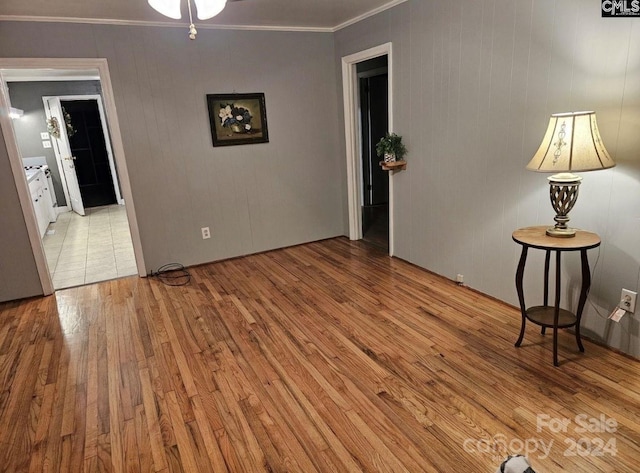 empty room featuring ornamental molding and light hardwood / wood-style flooring