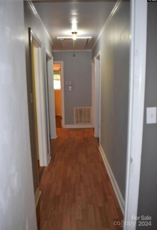 hall with ornamental molding and dark wood-type flooring