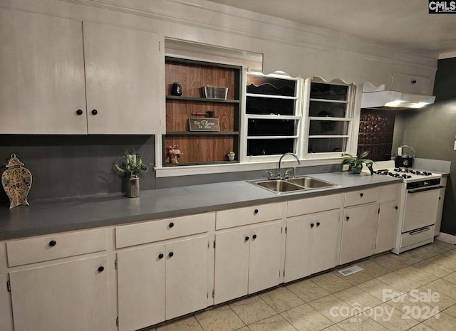 kitchen featuring white cabinets, light tile patterned floors, sink, and gas range gas stove