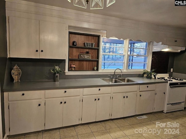 kitchen with sink, light tile patterned flooring, white range with gas stovetop, white cabinets, and ornamental molding