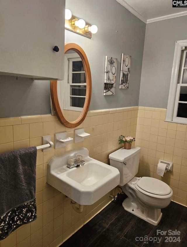 bathroom with ornamental molding, wood-type flooring, sink, and tile walls