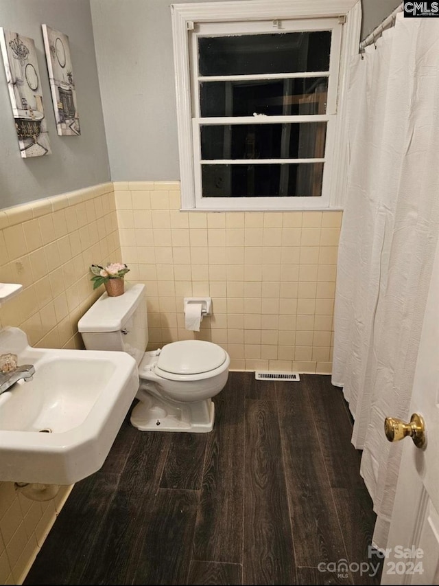 bathroom featuring hardwood / wood-style flooring, sink, toilet, and tile walls