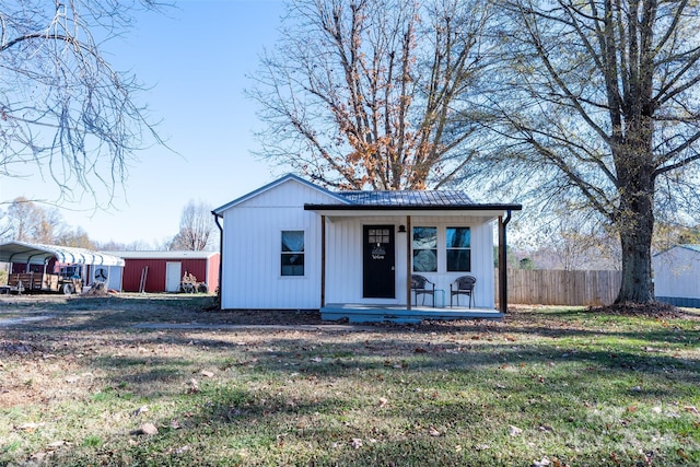 modern farmhouse style home featuring a carport, an outdoor structure, and a front lawn