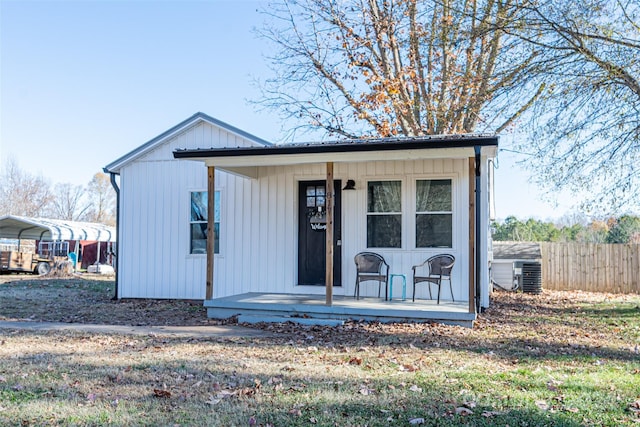 view of front facade with a carport, covered porch, and central AC