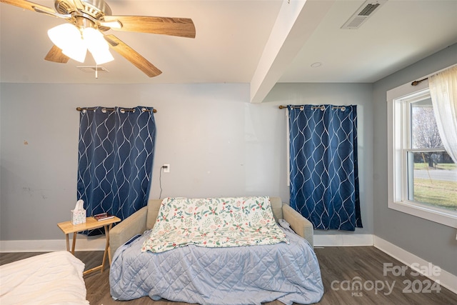 bedroom with beamed ceiling, ceiling fan, and dark wood-type flooring