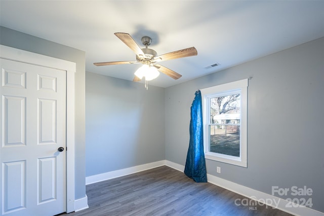 unfurnished room with dark hardwood / wood-style floors and ceiling fan