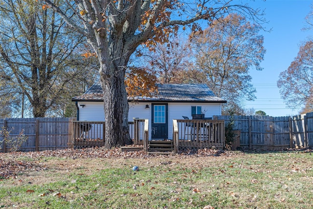 rear view of house with a deck and a lawn