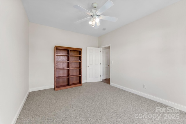 carpeted spare room with ceiling fan and baseboards