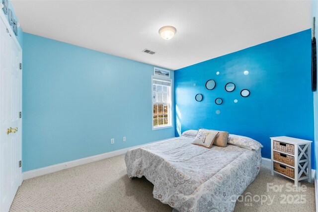 bedroom with light carpet, baseboards, an accent wall, and visible vents