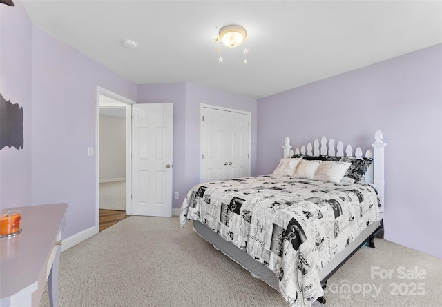 bedroom with light carpet, a closet, and baseboards