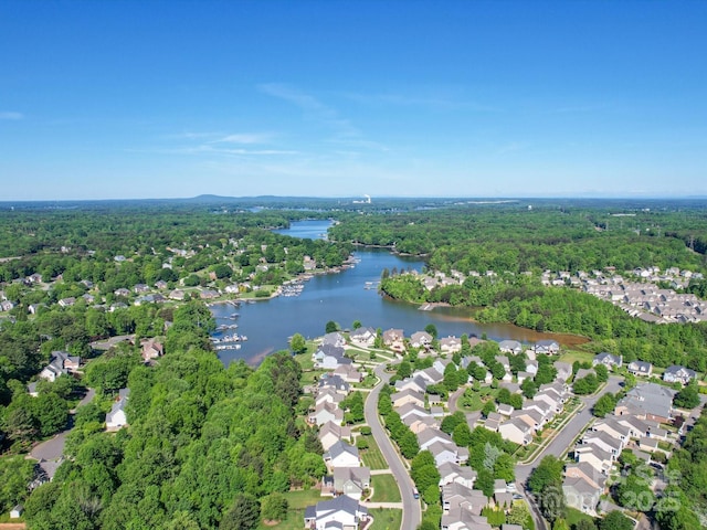 aerial view featuring a forest view, a water view, and a residential view