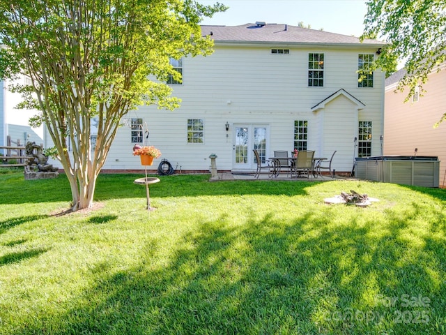 back of property featuring a yard and french doors