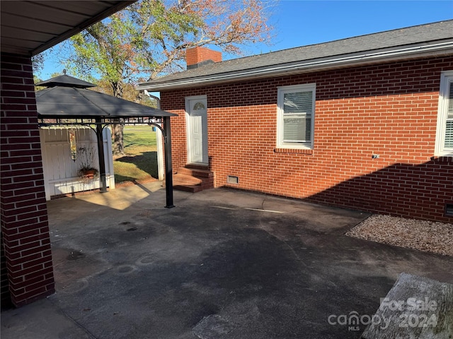 view of side of home featuring a gazebo and a patio