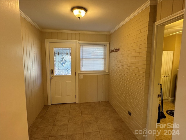 entryway featuring crown molding and brick wall