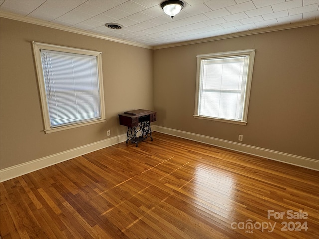 unfurnished room featuring hardwood / wood-style flooring and crown molding