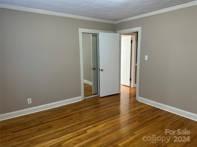 spare room with wood-type flooring and ornamental molding