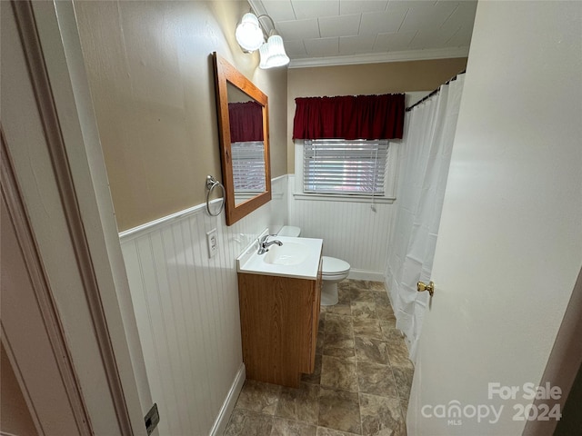 bathroom featuring toilet, vanity, and ornamental molding