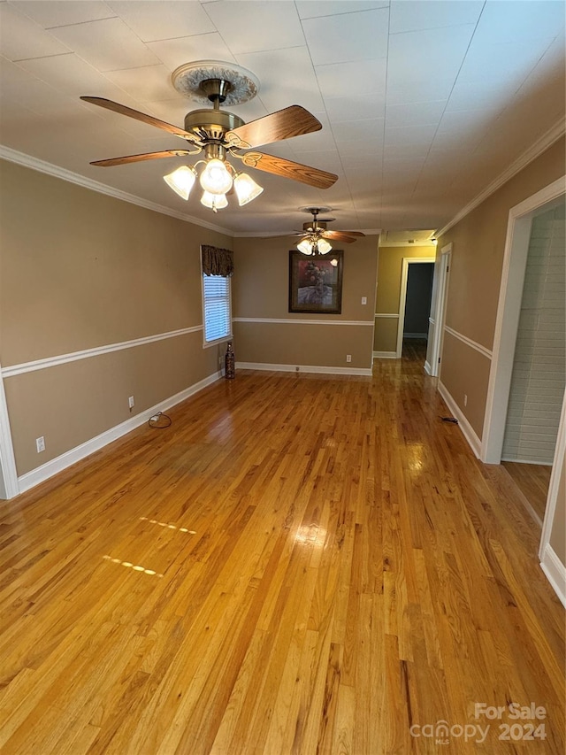 unfurnished room featuring light wood-type flooring, ceiling fan, and ornamental molding