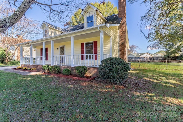 view of front of property featuring a porch, a front yard, fence, and a chimney