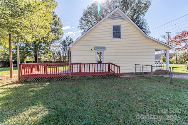 back of house with a lawn, crawl space, a wooden deck, and a fenced backyard