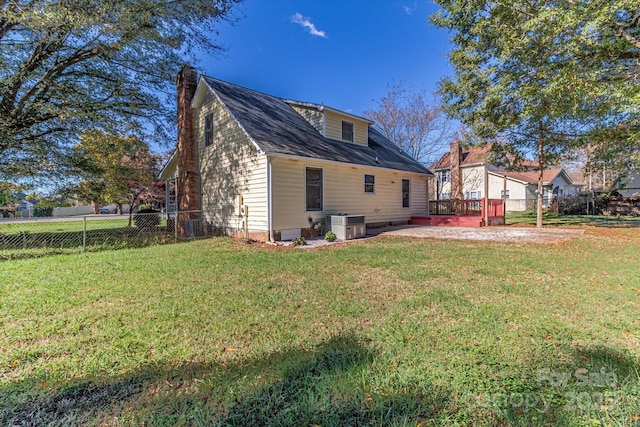 back of house featuring a lawn, central air condition unit, a chimney, and a patio area